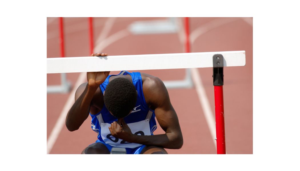 Athlete resting after hurdle race.